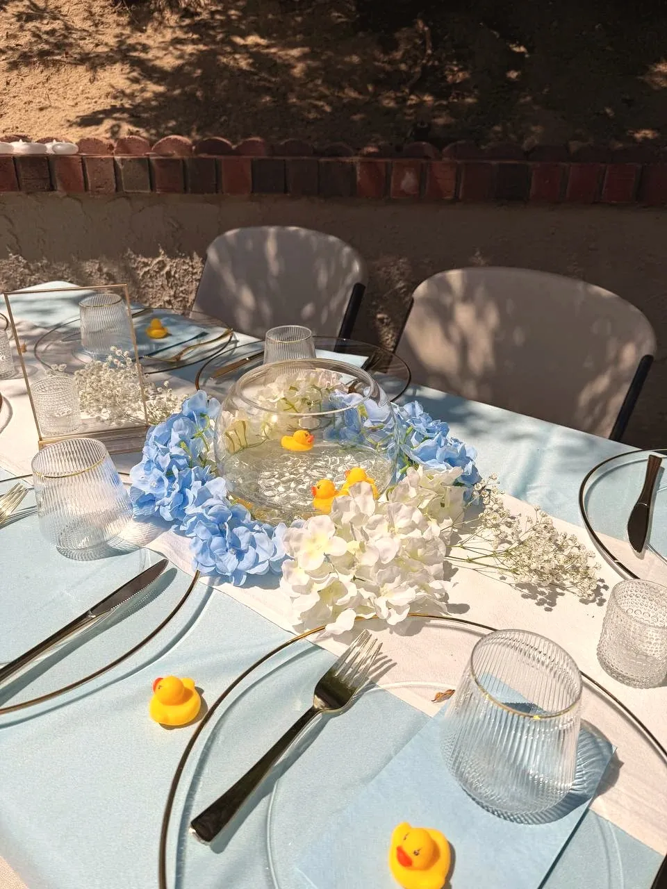 Dappled shade across the runner, with a photo frame and candle votives beside the flowers.