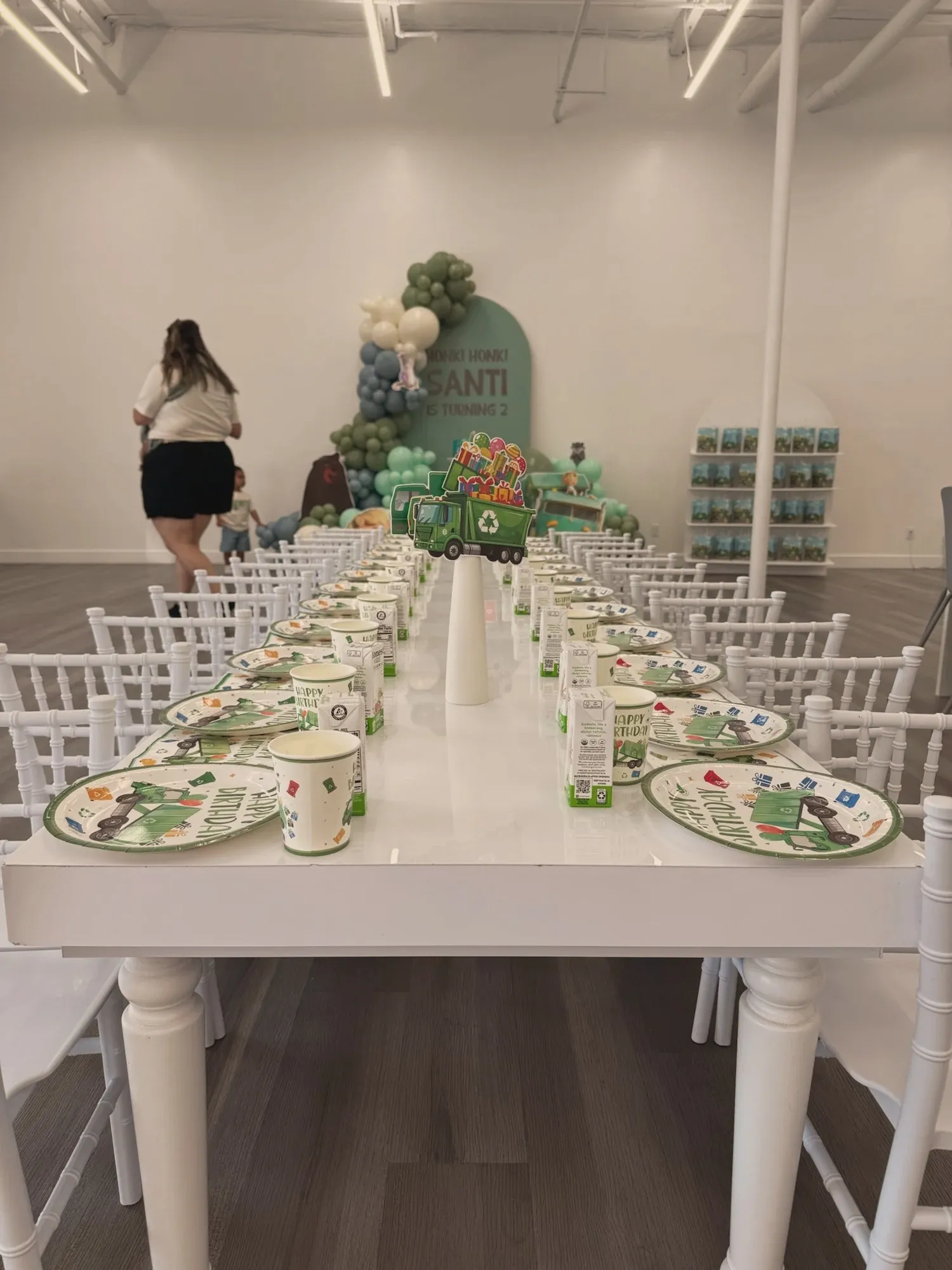 A kids' place setting with a Happy Birthday trash-truck plate, matching cup, and a juice box